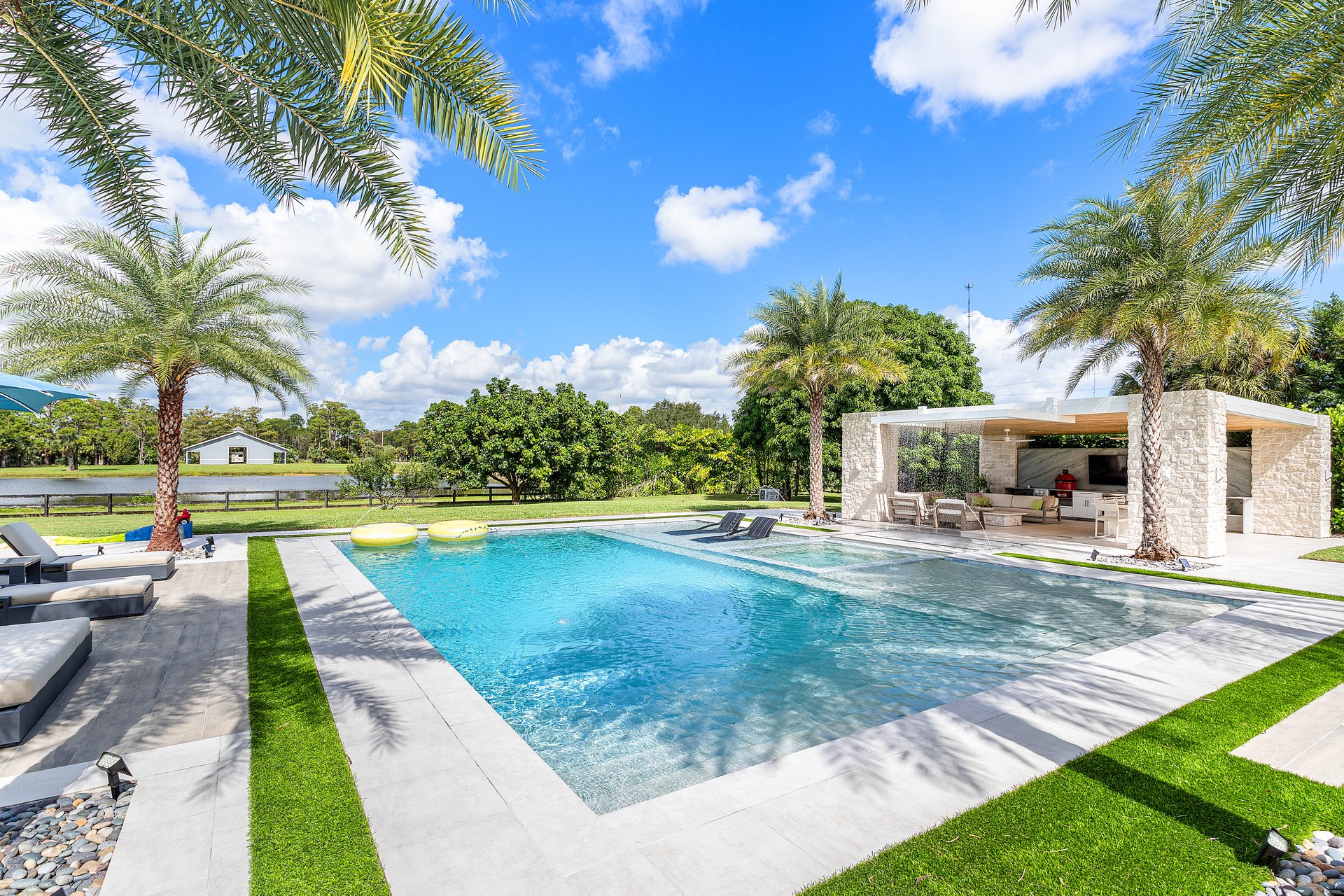 Resort pool with palm trees and pavilion in the background