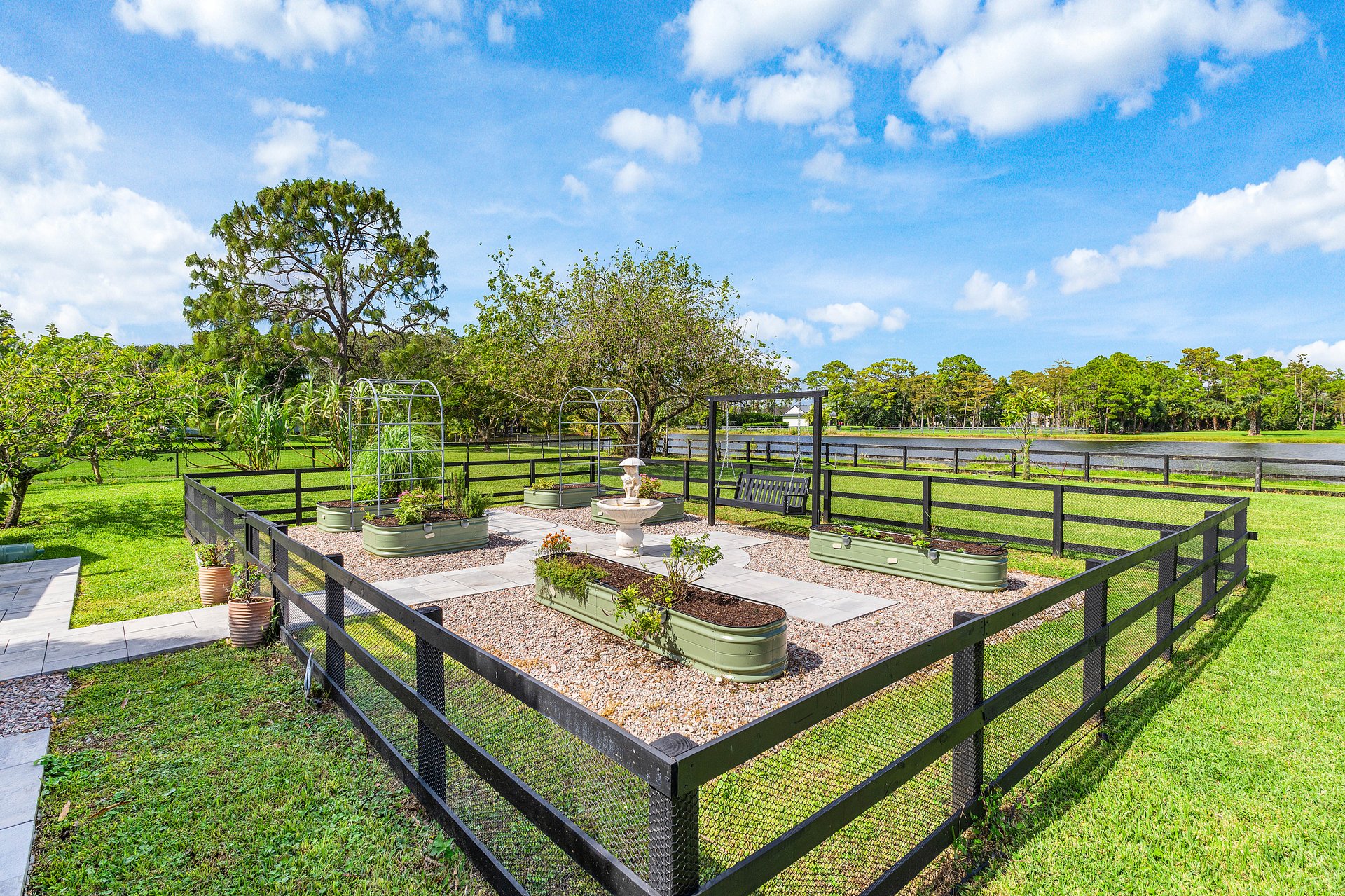 Raised-bed garden with stone fountain and lake views